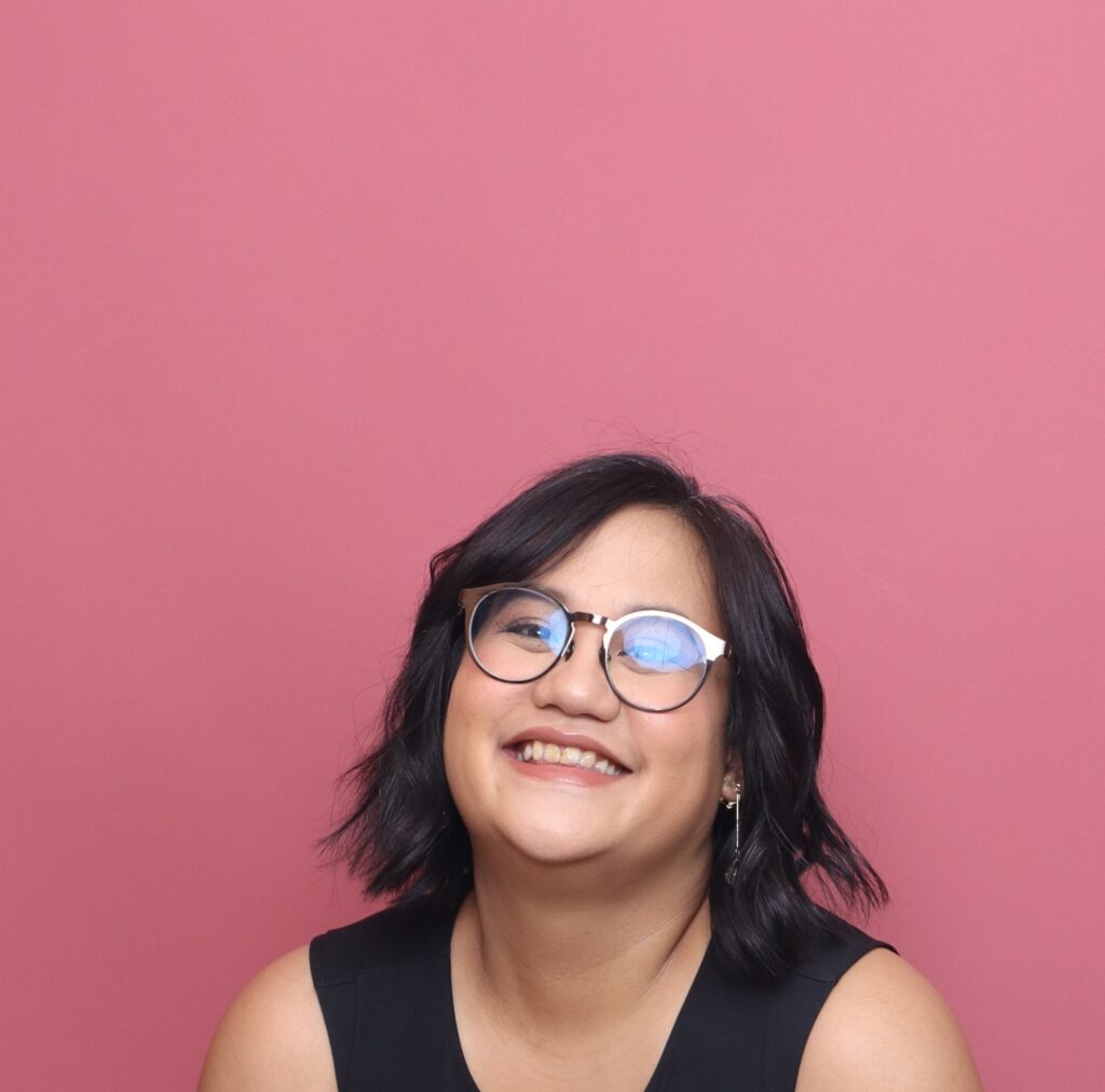 Nerdy girl in glasses grinning